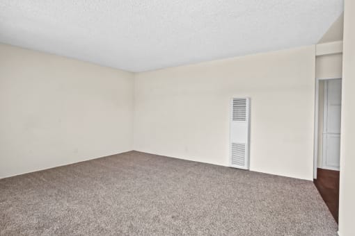 a bedroom with white walls and a carpeted floor