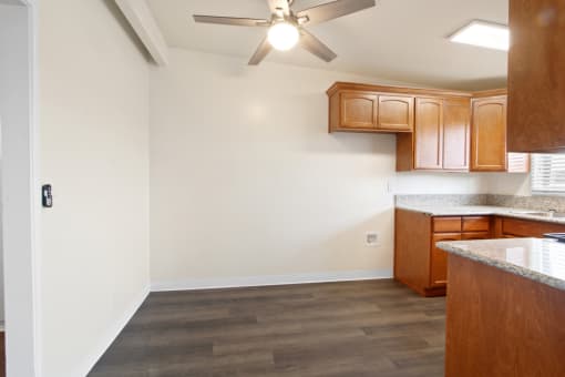 a kitchen with wood cabinets and a ceiling fan