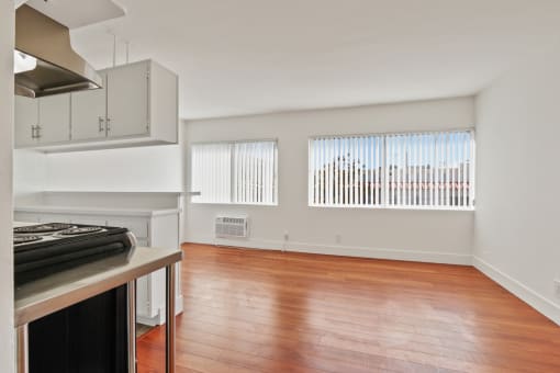 a kitchen and living room with wood floors and white walls