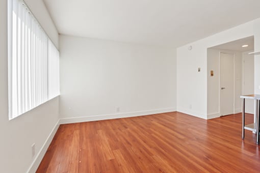 a bedroom with hardwood floors and white walls