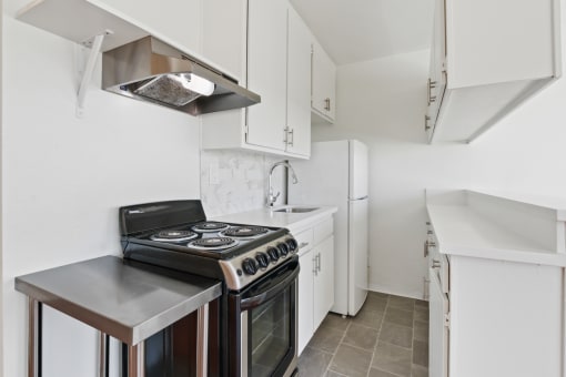 a kitchen with white cabinetry and a black stove top oven