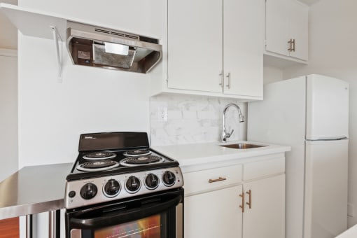 a kitchen with white cabinets and stainless steel appliances