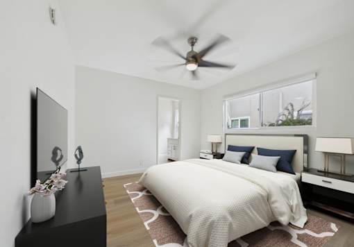 A bedroom with a large bed and a ceiling fan.