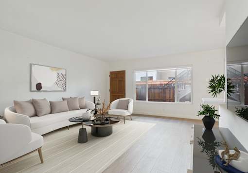 A modern living room with a white sofa, a coffee table, and a large window.