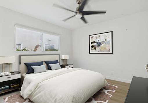 A bedroom with a large bed and a ceiling fan.