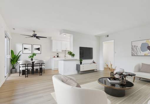 A modern living room with a white sofa, a black coffee table, and a dining table with chairs.