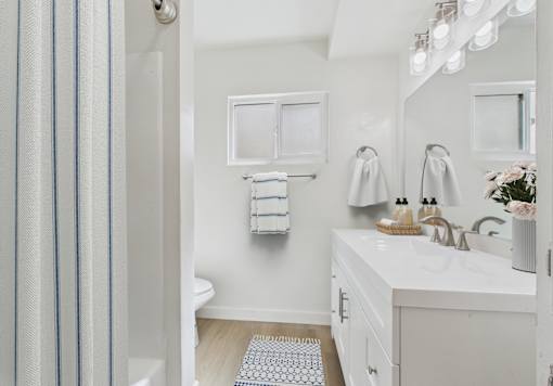 A bathroom with a white sink and a striped shower curtain.