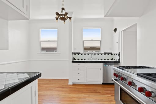 a white kitchen with a stove and a window