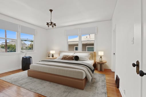 a bedroom with a bed and three windows