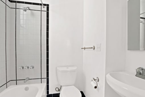 a white bathroom with a toilet and a shower