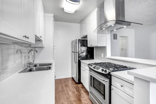a kitchen with white cabinets and stainless steel appliances