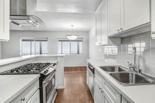 a kitchen with white cabinets and stainless steel appliances and a sink