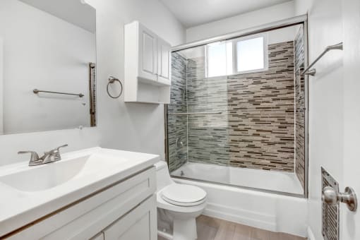 a bathroom with a shower and a sink and a toilet