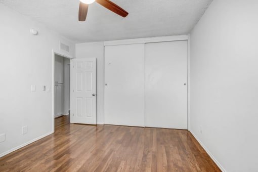 an empty living room with white walls and wood floors