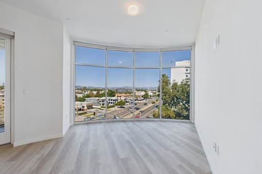 A room with a large window overlooking a street.