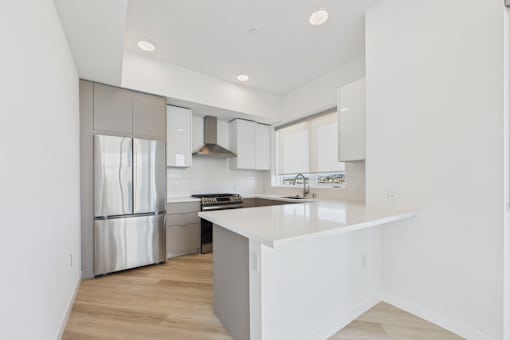 A modern kitchen with a white island and stainless steel appliances.