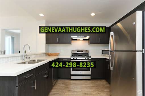 A modern kitchen with a stove and refrigerator, and a website address and phone number displayed on the wall.