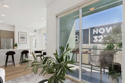 A living room with a glass door leading to a balcony.