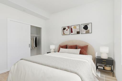 A bedroom with a large bed and a small table with a lamp.