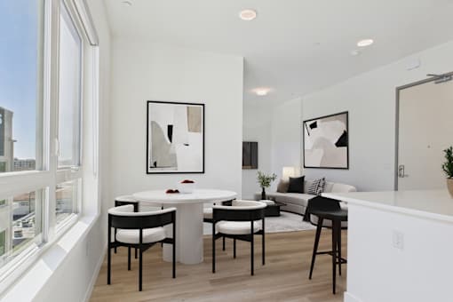 A modern dining room with a white table and chairs.