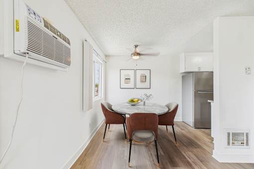 A dining room with a table and chairs.