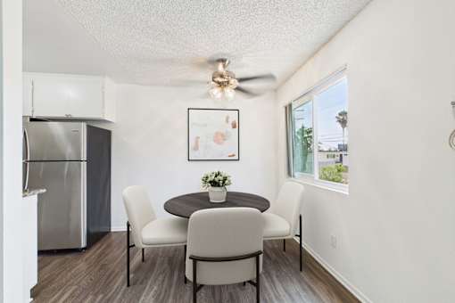 A dining room with a table and chairs.