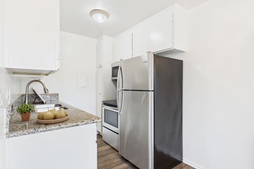 A kitchen with a granite countertop and stainless steel appliances.