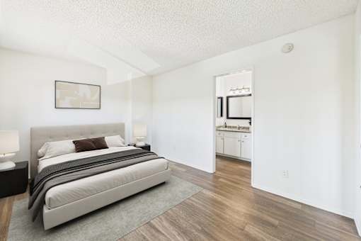 A bedroom with a large bed and a painting on the wall.