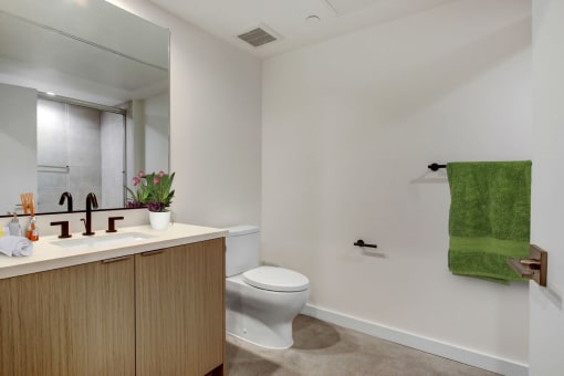 a bathroom with white walls and a green towel