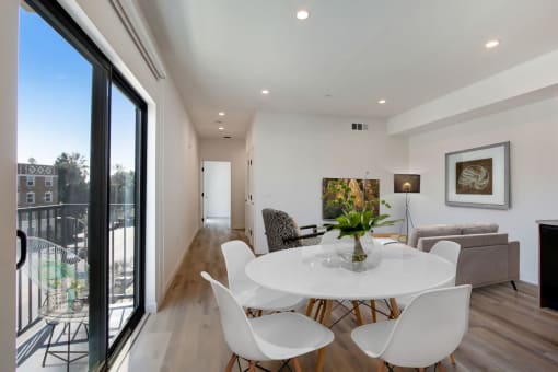 a dining area with a round table and white chairs