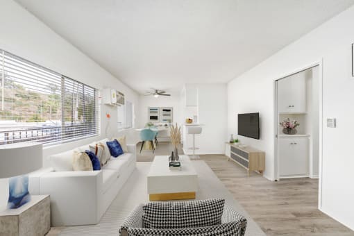 a living room with white furniture and a large window