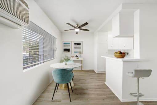 a dining room with a small table and a ceiling fan