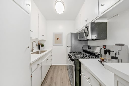 a modern kitchen with white cabinets and stainless steel appliances