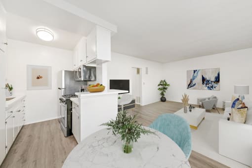 a living room and dining room with a table and a kitchen