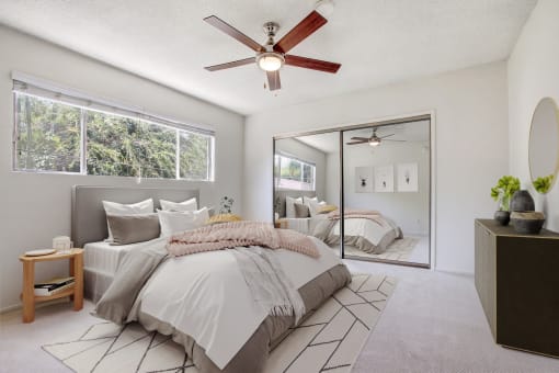 a bedroom with a large bed and a ceiling fan