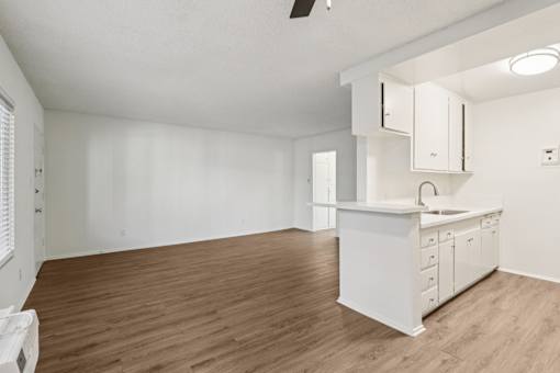A kitchen area with a white counter and cabinets.