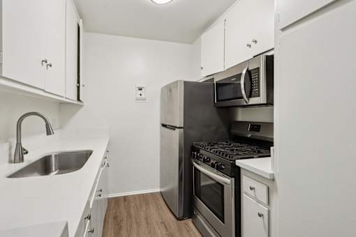 A kitchen with white cabinets and stainless steel appliances.