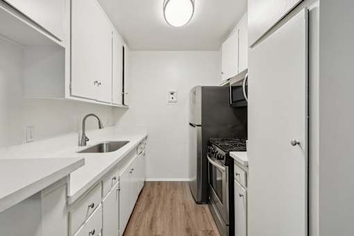 A kitchen with white cabinets and appliances.