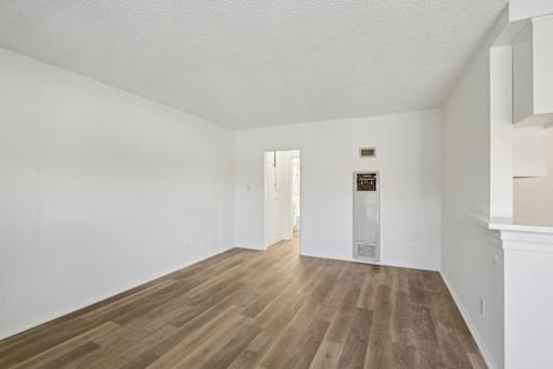 A room with wooden flooring and white walls.
