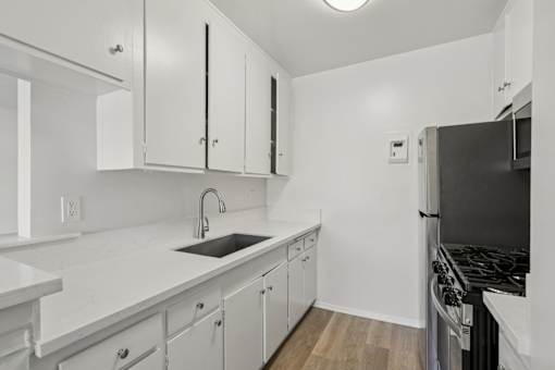 A kitchen with white cabinets and a black stove top oven.