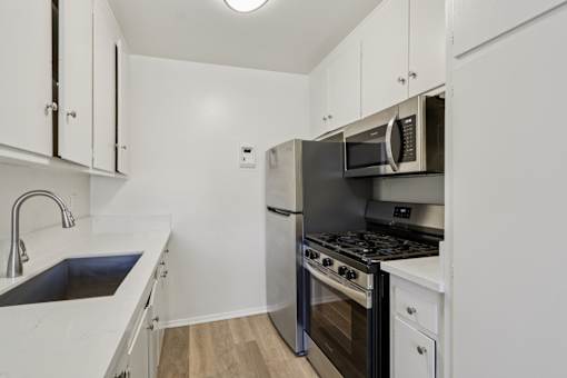 A kitchen with white cabinets and stainless steel appliances.