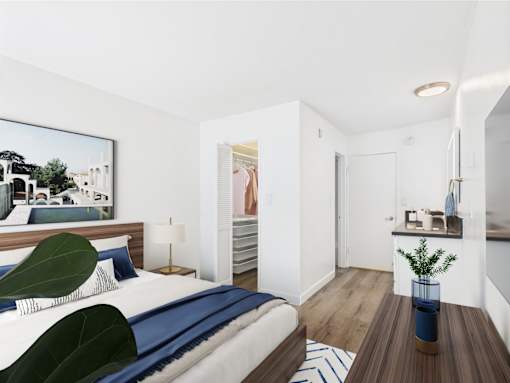 A bedroom with a bed, a chair, a lamp, a painting, a plant, and a small table.