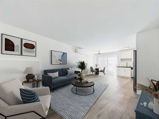 A living room with a grey couch, a coffee table, and a dining table.