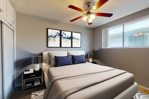A bedroom with a large bed and a ceiling fan.