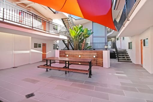 a courtyard with a wooden bench and a table