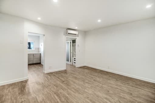 a living room with white walls and a wooden floor