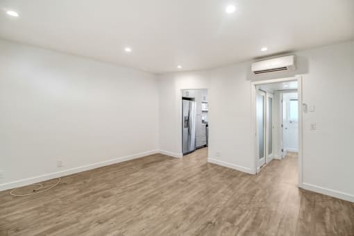 a living room with white walls and a wooden floor