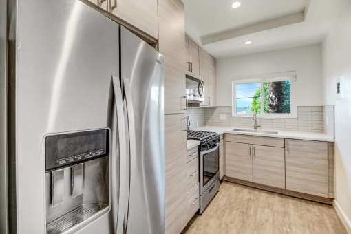 a modern kitchen with stainless steel appliances and white cabinets