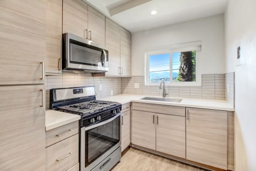 an updated kitchen with stainless steel appliances and wooden cabinets