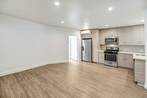 an empty living room with white walls and wood flooring